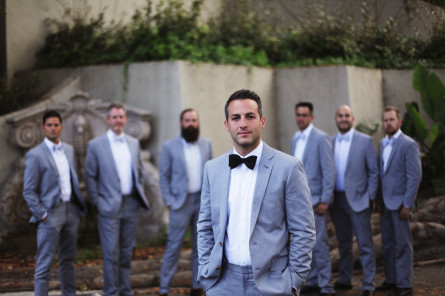 groom posing with groomsmen in the background